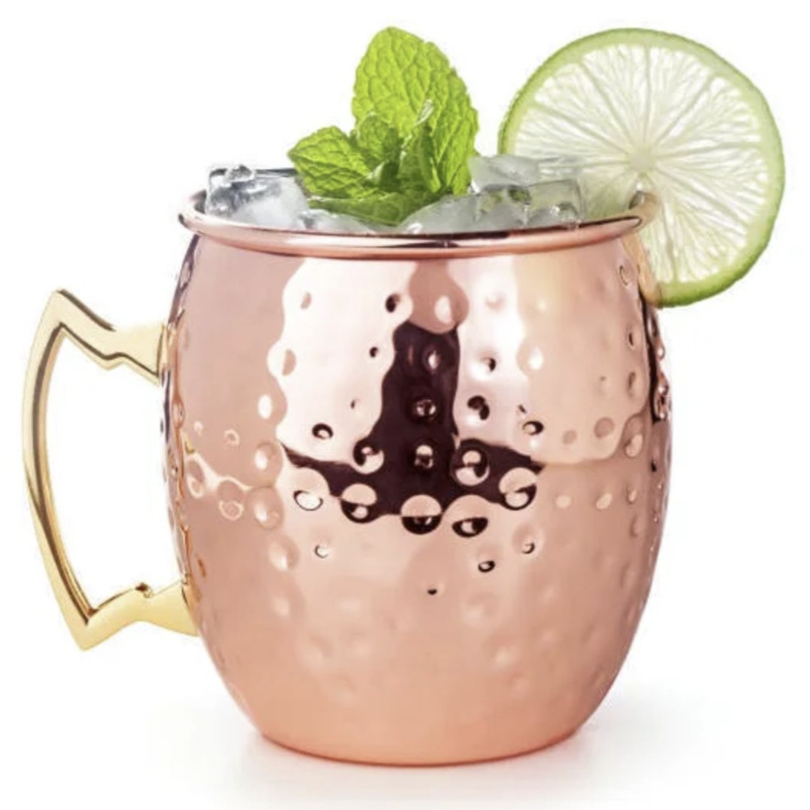 A copper mug with a hammered texture, featuring a gold handle, is filled with ice and garnished with mint leaves and a lime slice.