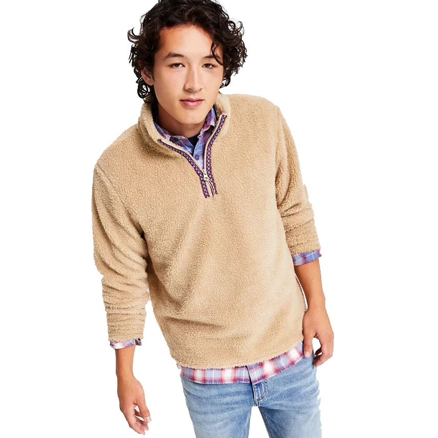 Man wearing a beige fleece pullover with a half-zip front, over a blue plaid button-up shirt and light blue jeans.