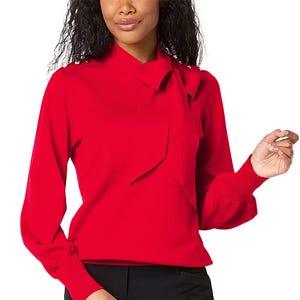 A woman wearing a red long-sleeved blouse with a tie-neck detail.