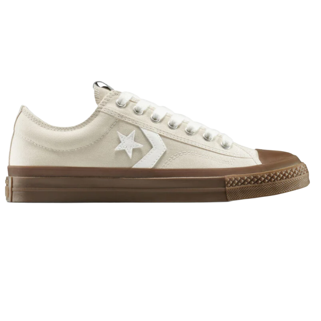 Cream-colored low-top sneaker with white laces, a brown sole, and a white star and chevron logo on the side.