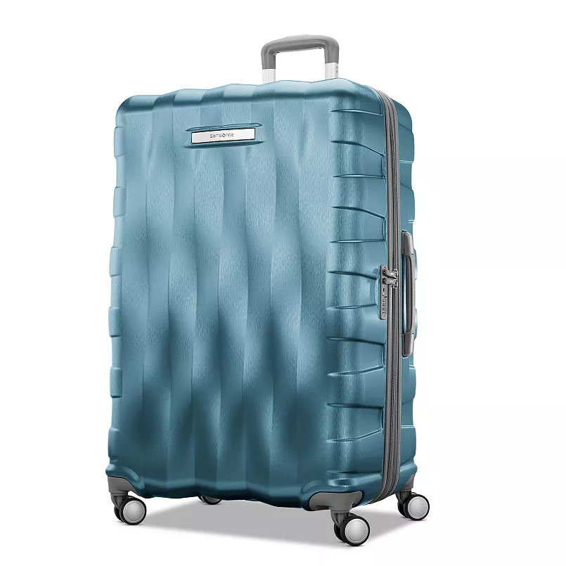 Blue hard-shell suitcase with a textured surface, four spinner wheels, and a telescopic handle.