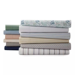 A stack of folded fabric, including various solid colors and patterned designs.