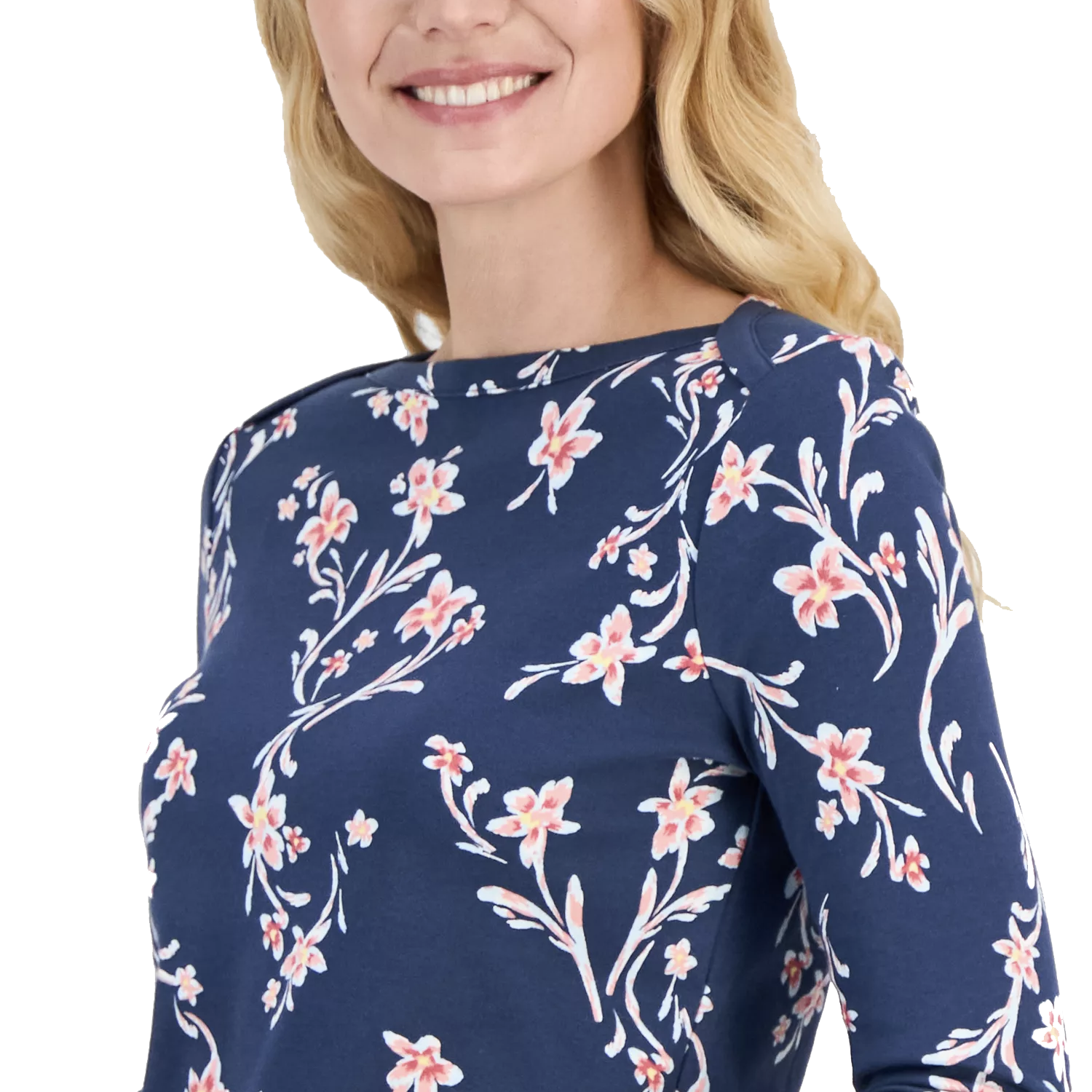 A woman wearing a navy blue top with a pink floral print, featuring long sleeves and a round neckline.