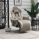 A plush, gray and beige recliner with a headrest, cup holder, and footrest is situated in a modern living room setting, featuring a decorative plant, wall art, and a sleek black shelf with decorative items.