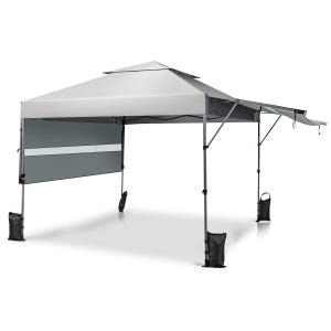 A gray pop-up canopy tent with a slanted roof and extended awning, featuring a sidewall and weighted bags at each leg for stability.