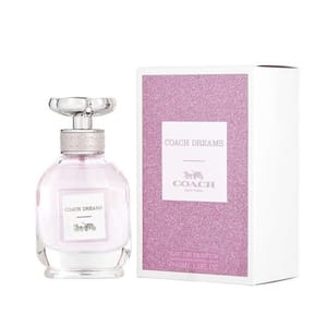 A translucent pink bottle of Coach Dreams perfume with a glass cap, alongside its glittery pink box with white borders and the Coach logo.