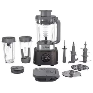 The Ninja Ultimate Blender System includes a blender base with a large blending jar, two personal-size cups with lids, various blade attachments, a food processor lid, and slicing/shredding discs.
