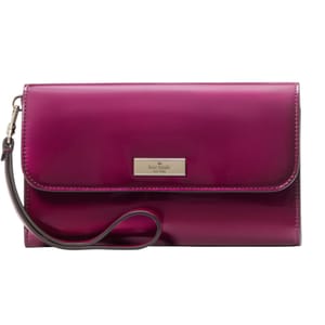 A glossy magenta clutch with a detachable wrist strap and a rectangular metal logo plaque on the front flap.