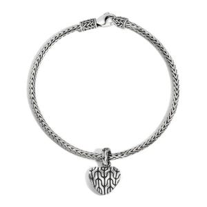 Silver chain bracelet with a heart-shaped charm featuring a black, wavy pattern. The design is sleek and elegant.