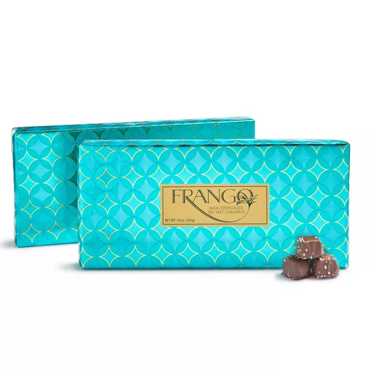 Frango Milk Chocolate Sea Salt Caramels in turquoise packaging with a geometric pattern, featuring a gold label; includes a portion showing caramel pieces topped with sea salt.