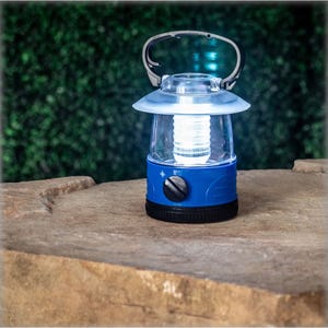 4pk BrightEase LED Mini Lanterns feature a compact, blue, and silver design with an adjustable dial for brightness control. They have a sturdy handle for easy carrying, suitable for outdoor and emergency use.