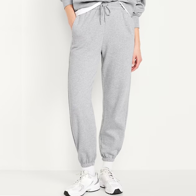 Gray sweatpants with a drawstring waist and elasticated ankle cuffs, paired with white sneakers.