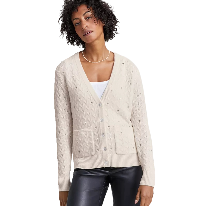 A beige, V-neck, textured cardigan with front buttons and pockets, worn over a white top.