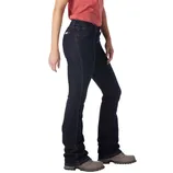 A person is wearing dark blue bootcut jeans paired with grey lace-up shoes and a red top.