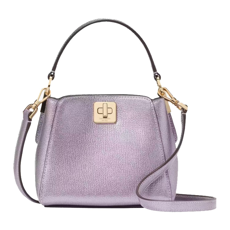 A compact metallic purple crossbody bag from Kate Spade, featuring a structured design with a top handle, detachable shoulder strap, and a signature turn-lock closure in gold-toned hardware.