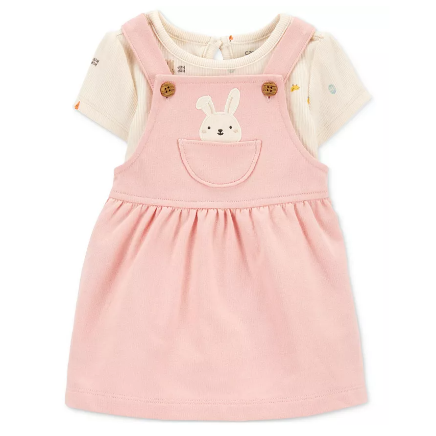 A cute 2-piece baby outfit featuring a light pink pinafore dress with a bunny design on the pocket, layered over a short-sleeve cream-colored shirt with subtle patterns.