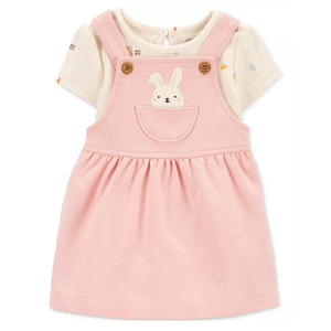 A cute 2-piece baby outfit featuring a light pink pinafore dress with a bunny design on the pocket, layered over a short-sleeve cream-colored shirt with subtle patterns.