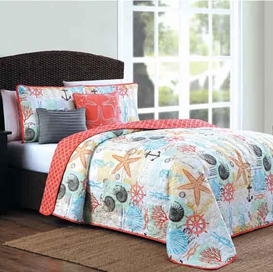 The 5pc Beach Queen Quilt Set features a coastal-themed quilt with starfish, seashells, and coral designs in light blue, orange, and white. It includes matching shams and decorative cushions.