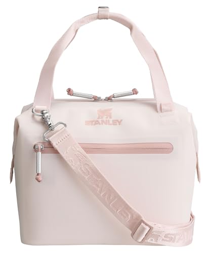 A light pink Stanley soft cooler bag with a zippered front pocket, adjustable shoulder strap, and two handles.
