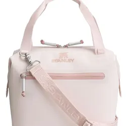 A light pink Stanley soft cooler bag with a zippered front pocket, adjustable shoulder strap, and two handles.