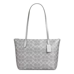 A gray Coach tote bag with the signature 'C' pattern, featuring long handles and a brand tag attached.