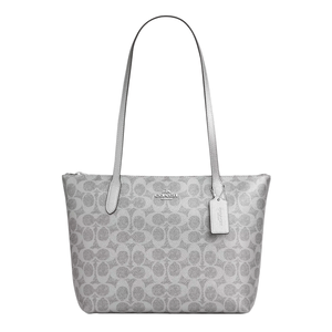 A gray Coach tote bag with the signature 'C' pattern, featuring long handles and a brand tag attached.