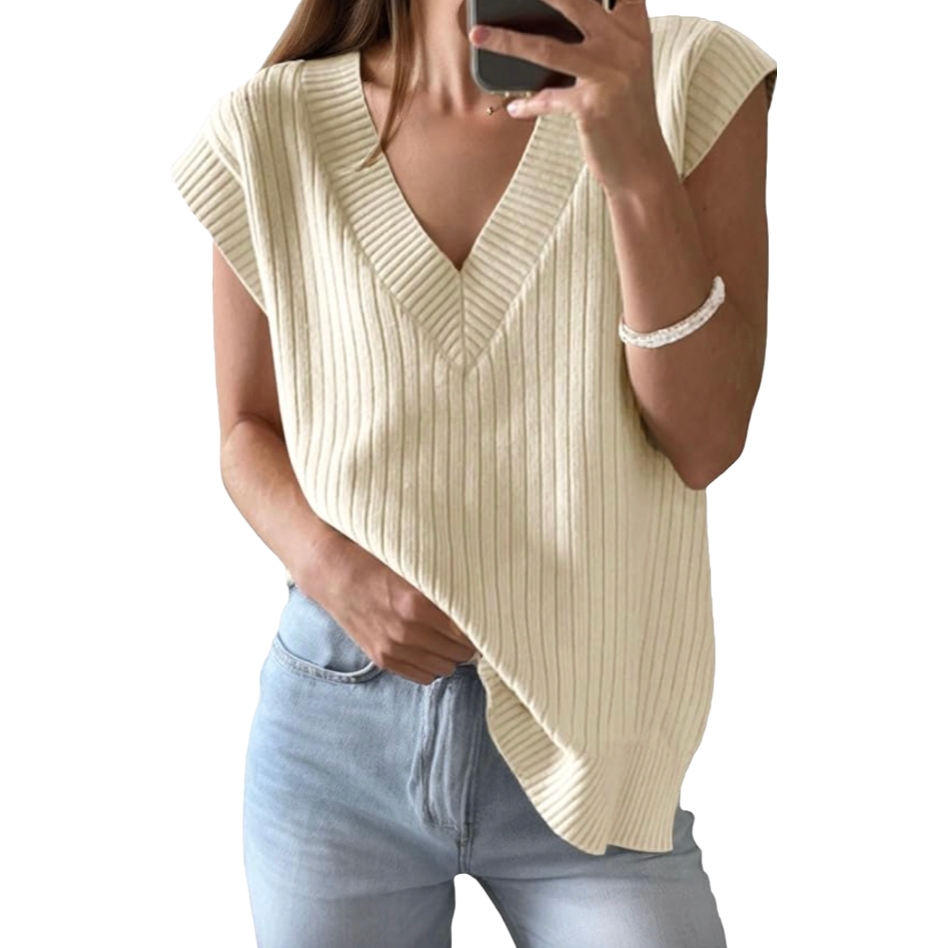 A sleeveless, ribbed knit sweater in cream with a V-neck design is paired with light blue jeans.