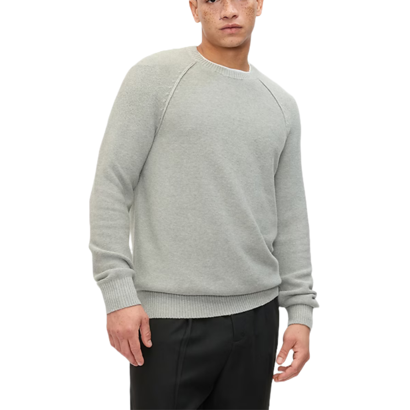 Light grey garter-knit crewneck sweater with raglan sleeves and ribbed cuffs and hem, paired with black pants.
