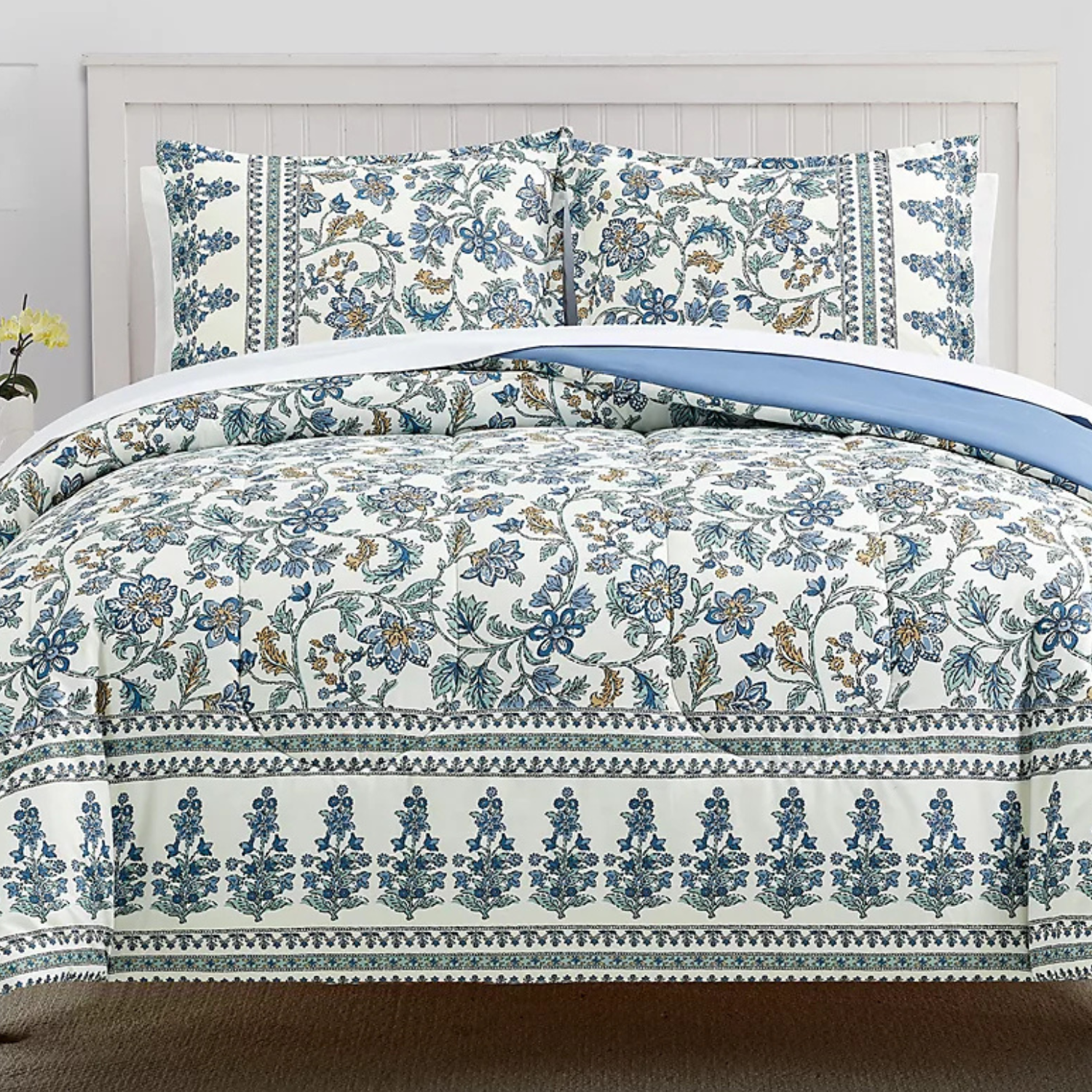 A 3-piece floral comforter set featuring a design of blue and cream-colored flowers with intricate borders. The set includes a comforter and two matching pillow shams, creating a cohesive and elegant look for a bed.