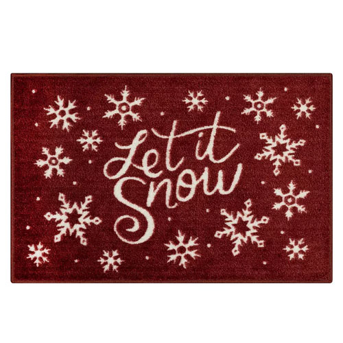 A red doormat with white snowflakes and the phrase \“Let it Snow\“ in cursive font.