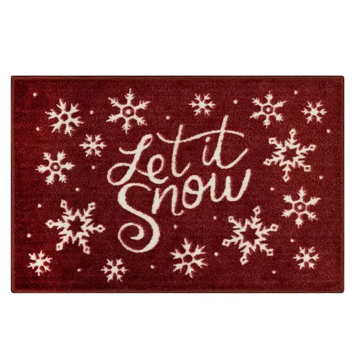 A red doormat with white snowflakes and the phrase \“Let it Snow\“ in cursive font.