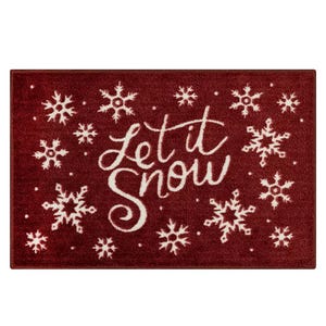 A red doormat with white snowflakes and the phrase \“Let it Snow\“ in cursive font.