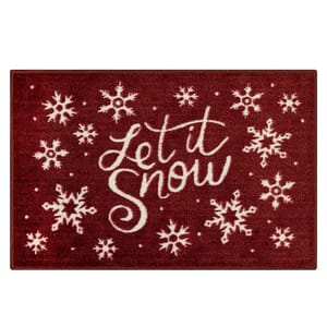 A red doormat with white snowflakes and the phrase \“Let it Snow\“ in cursive font.