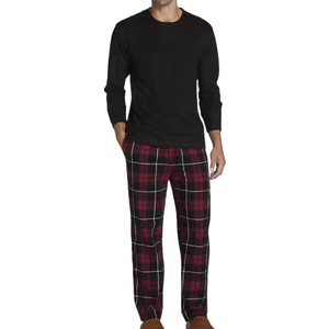 Men's pajama set featuring a long-sleeve black crew neck shirt and red plaid pants, paired with brown slippers.