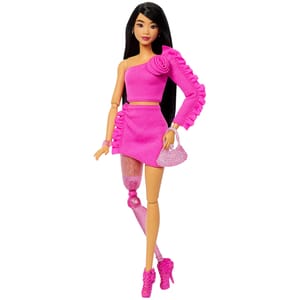A doll with long black hair, wearing a pink one-shoulder top and skirt, featuring a prosthetic leg and pink high-heeled shoes, holding a small pink purse.