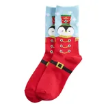 Festive socks featuring a penguin wearing a Nutcracker-style outfit with red and blue colors and holiday-themed details.