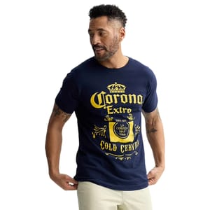 Men's Corona Graphic Tee featuring a navy blue color with a bold yellow \“Corona Extra\“ logo and motifs, including a crown and decorative elements. The text reads \“La Cerveza Mas Fina,\“ and the shirt has short sleeves and a casual fit.