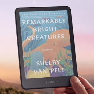 Kindle ColorSoft e-reader displaying \“Remarkably Bright Creatures\“ by Shelby Van Pelt, with the tagline \“Color you can't put down.\“