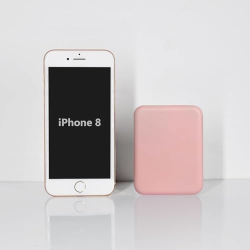 An iPhone 8 stands next to a pink, rectangular power bank.