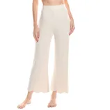 White knit pants with a ribbed texture, featuring a high waist and scalloped hems, worn by a person.