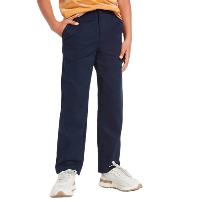 A child wearing navy blue trousers and white sneakers with a yellow and orange striped shirt.
