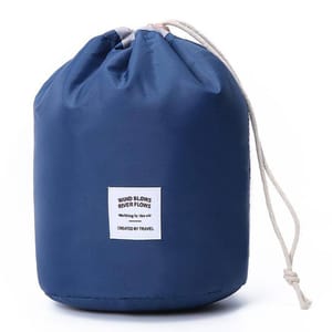 A blue cylindrical drawstring bag with a simple design, featuring a white square patch that reads \“WIND BLOWS RIVER FLOWS Walking in the air CREATED BY TRAVEL.\“