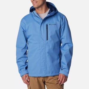A man wearing a blue Columbia rain jacket with a zipper and hood.