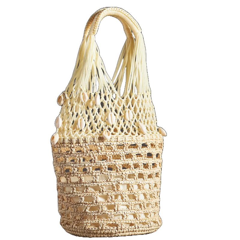 A beige bucket bag featuring a woven design with open square patterns. The top section is made of a macramé net adorned with seashell embellishments. It has sturdy handles formed from the same macramé material.