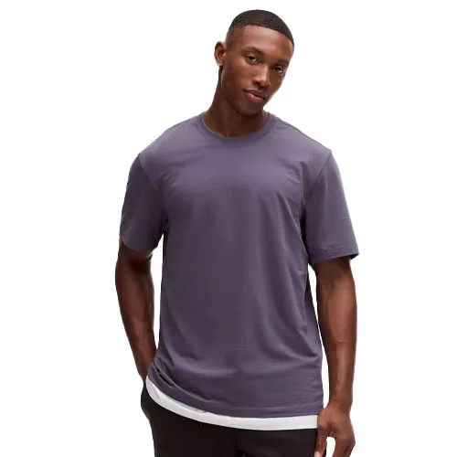 A man wearing a plain, short-sleeve, crew neck shirt in a muted purple color.