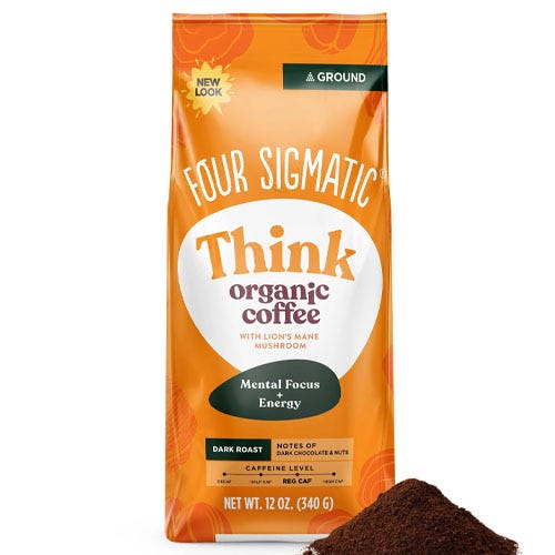 an orange bag of coffee behind a pile of coffee grounds