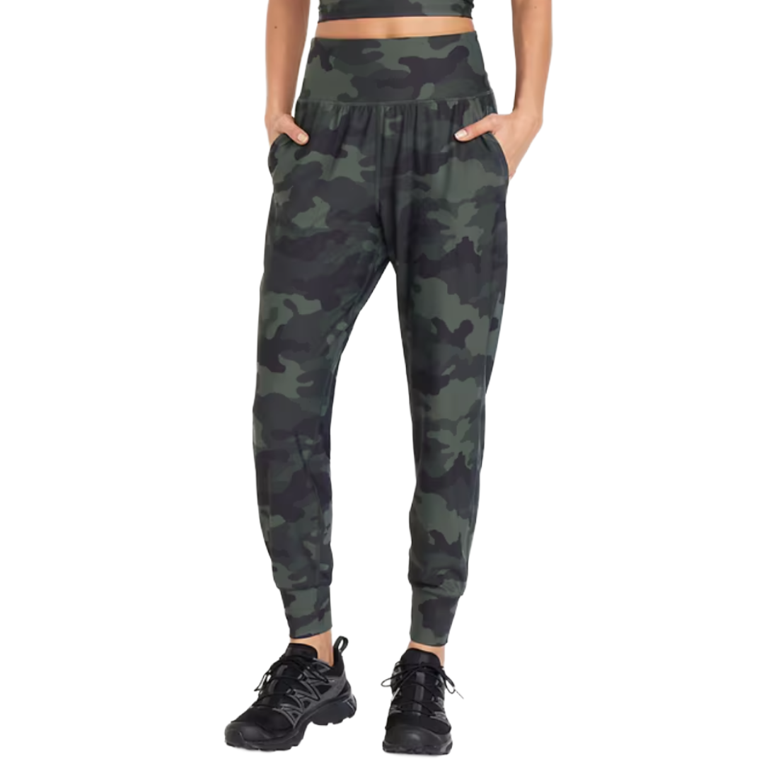 Camo print joggers with a high waistband and side pockets, paired with black athletic shoes.
