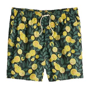 Swim shorts with a lemon and leaf pattern on a dark background, featuring an elastic waistband and drawstring.