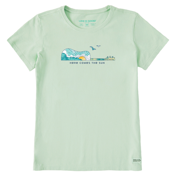 Light green T-shirt with a guitar-shaped graphic featuring a sun, sky, and birds. Below the graphic, \“Here Comes the Sun\“ is printed. Made by Life is Good.