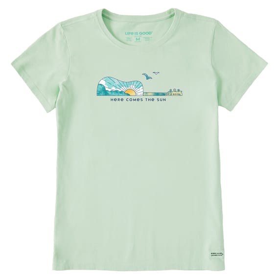 Light green T-shirt with a guitar-shaped graphic featuring a sun, sky, and birds. Below the graphic, \“Here Comes the Sun\“ is printed. Made by Life is Good.